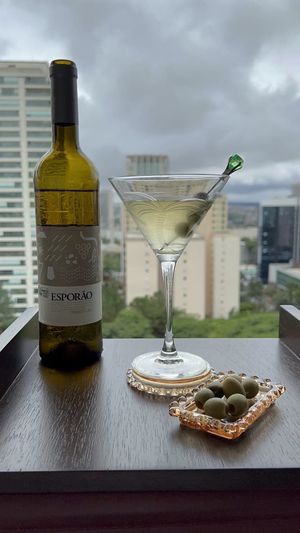 Taça de Dry Martini ao lado de garrafa de vinho português orgânico Esporão Colheita Branco